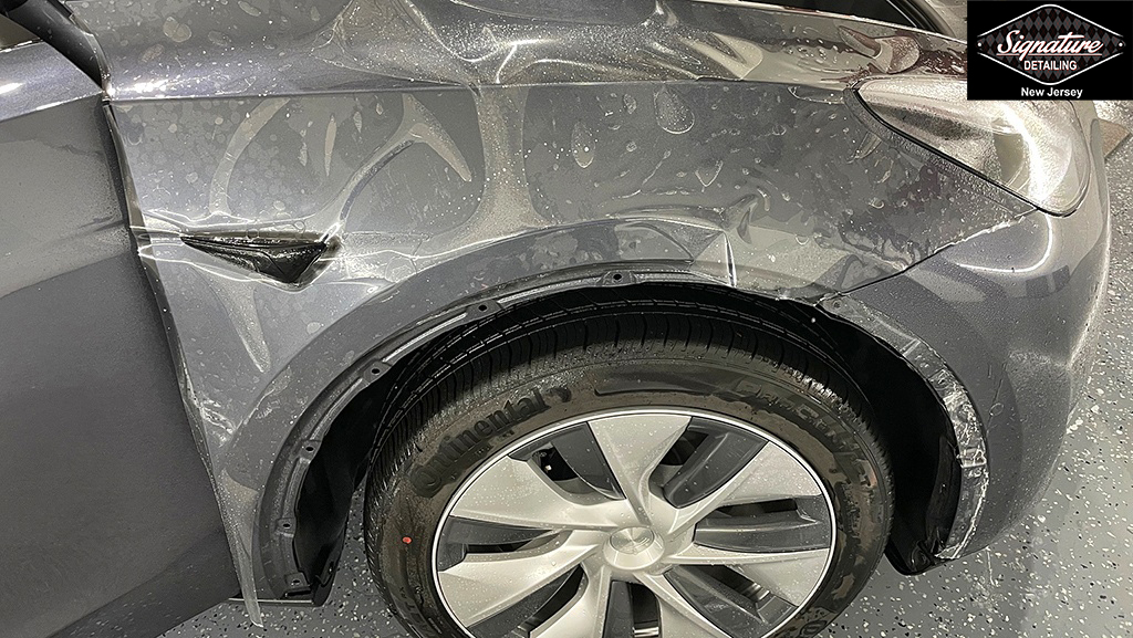 Tesla Model Y Positioning PPF in Place for Installation - Signature Detailing NJ