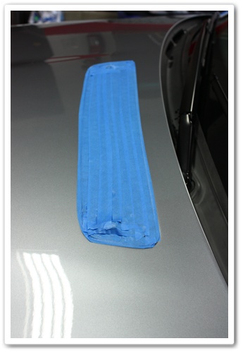 Taped up hood vent on a BMW M3 before polishing