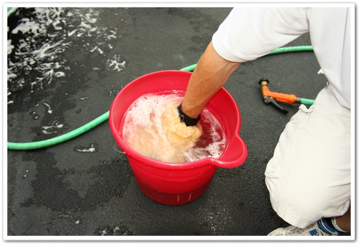 Rinsing a sheepskin wash mitt in the rinse bucket prior to getting more shampoo on your mitt