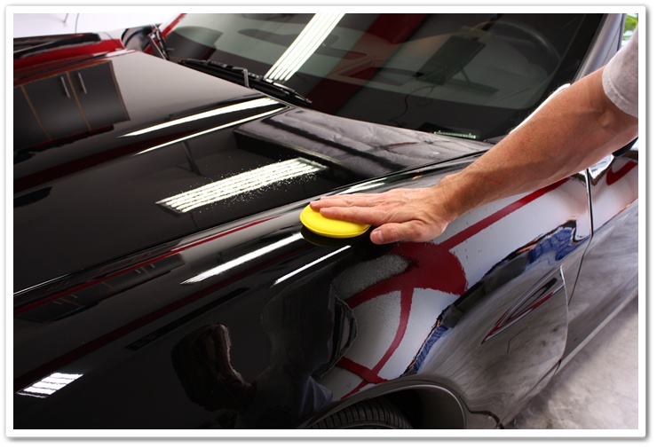 Optimum Opti-Seal being spread on to the paint of a black Corvette